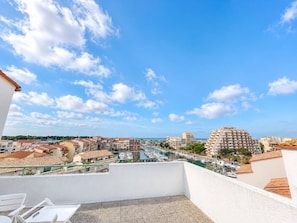 Un balcón con vista a un puerto deportivo y edificios.