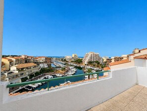 A coastal cityscape with a marina, buildings, and a clear blue sky. - Spacious apartment with sea view - 7 guests (Canet-en-Roussillon)