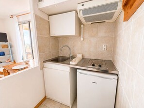 A compact kitchen with a sink, dishwasher, and a small countertop. - Studio sea view, AC, pets allowed - 2 guests (Canet-en-Roussillon)