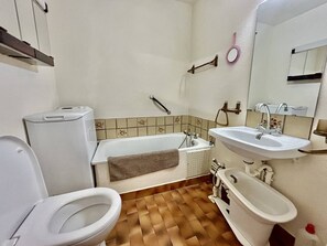 Ein Badezimmer mit Toilette, einer Badewanne, einem Waschbecken und einem Bidet.