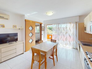 A modern kitchen with a stove, sink, and a television on a cabinet. - Spacious studio with AC and terrace - 4 guests (Menton)