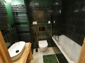 Un baño con lavamanos, inodoro y bañera blancos.