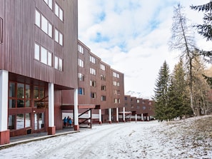 A multi-story building with a modern architectural design, featuring large windows and a flat roof. - Charming apartment, balcony - 6 guests (Les Arcs 1800)
