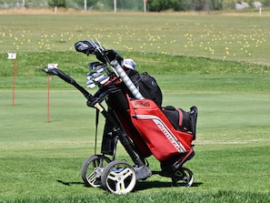 A golf cart with a red bag labeled "PING" on a golf course. - Luxury apartment near golf course - 4 guests (Barcelonnette)