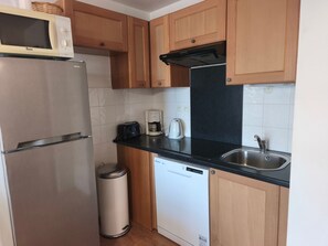 A compact kitchen with a stainless steel refrigerator, a microwave, a coffee maker, and a dishwasher. - Apartment - 6 guests, mountain view (Orcières Merlette)
