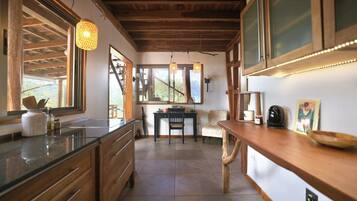 A kitchen with wooden cabinets, a countertop, a dining area with a table and chairs, and a window with a view.