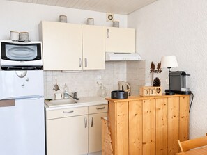A compact kitchen with a microwave, stove, and coffee maker. - Apartment, panoramic view - 4/5 guests (Chamrousse)