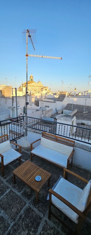 A rooftop terrace with outdoor seating, a satellite dish, and a view of a historic building. - Roof-Top Maisonette | Old Town by TrulloVista (Martina Franca)