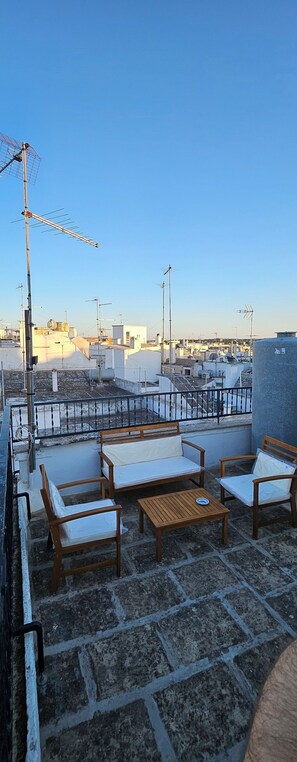 Une terrasse sur le toit, dotée d’un espace extérieur aménagé et offrant une vue dégagée sur le paysage urbain.