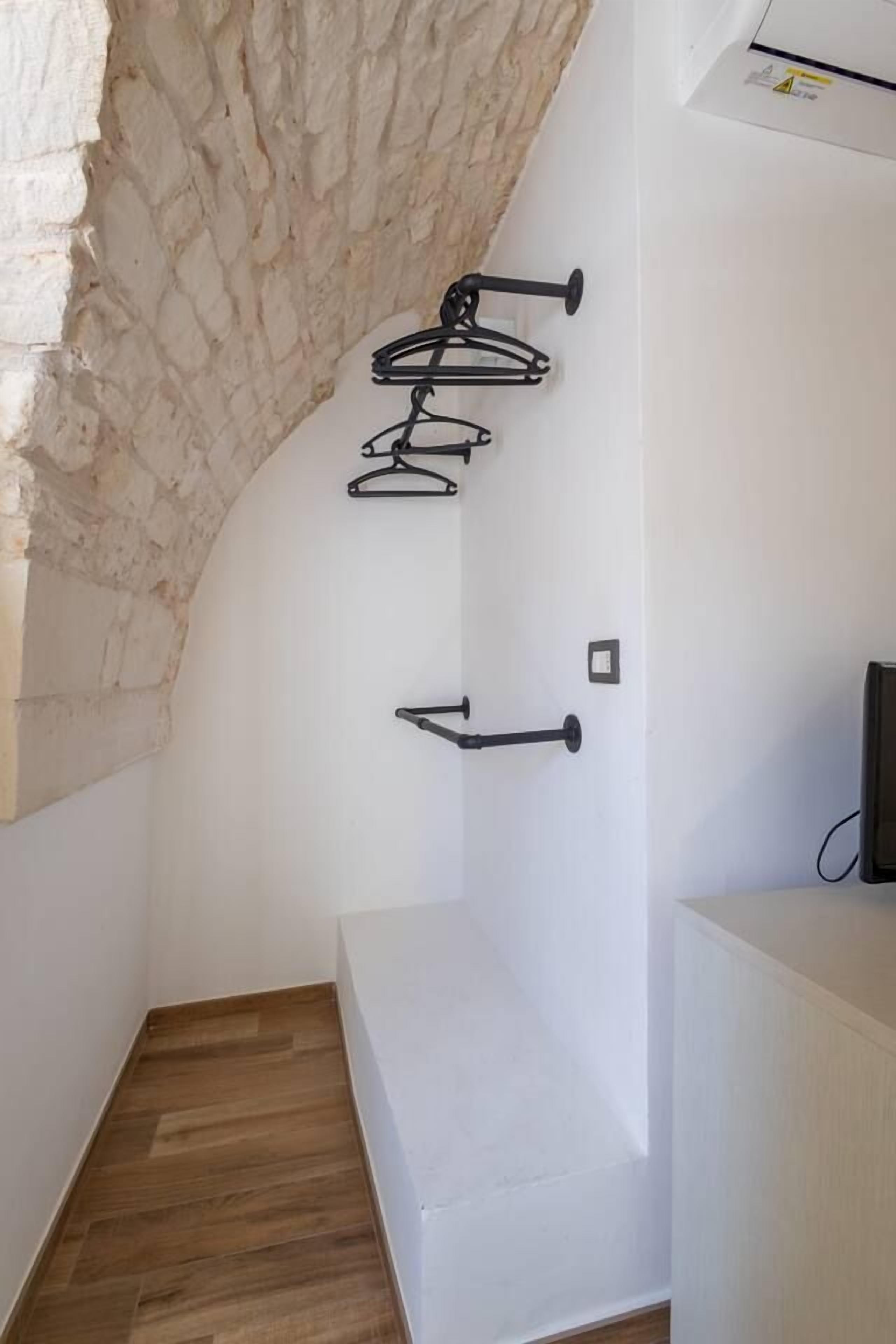 Ein Zimmer mit weißer Wand, Holzboden und einem Steingewölbe.