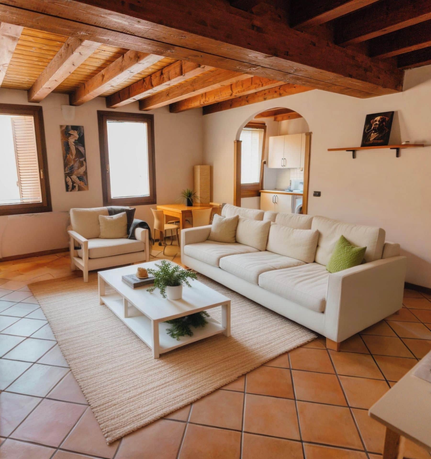 A living room with a sofa, coffee table, and chairs, a kitchen area, and a dining table.