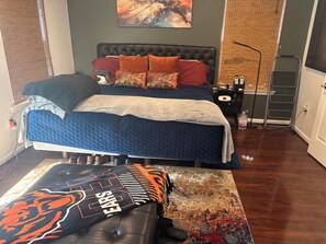 A bedroom with a bed, bedside table, lamp, and a chair with a blanket. - 3-bedroom townhome in peaceful Hillcrest Heights with AC (Hillcrest Heights)