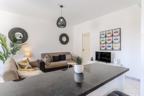 Ein modernes Wohnzimmer mit einer Couch, einem Couchtisch und einem Fernseher.