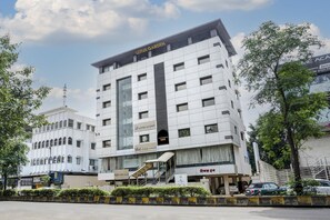 Un hotel moderno con un llamativo letrero 'Lotus Garden', una casa adosada y un restaurante 'Kerry Masala'.
