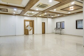 Una habitación amplia con piso pulido, un letrero de prohibido fumar y una ventana con persianas.