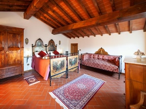 A traditional room with a bed, bench, and wooden furniture. - Tuscan Hideaway With Panoramic View (Poppi)