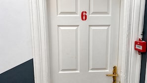 A white door with a number '6' and a red fire alarm box. - Ensuite Studio, Sleeps 4 With Wifi (London)
