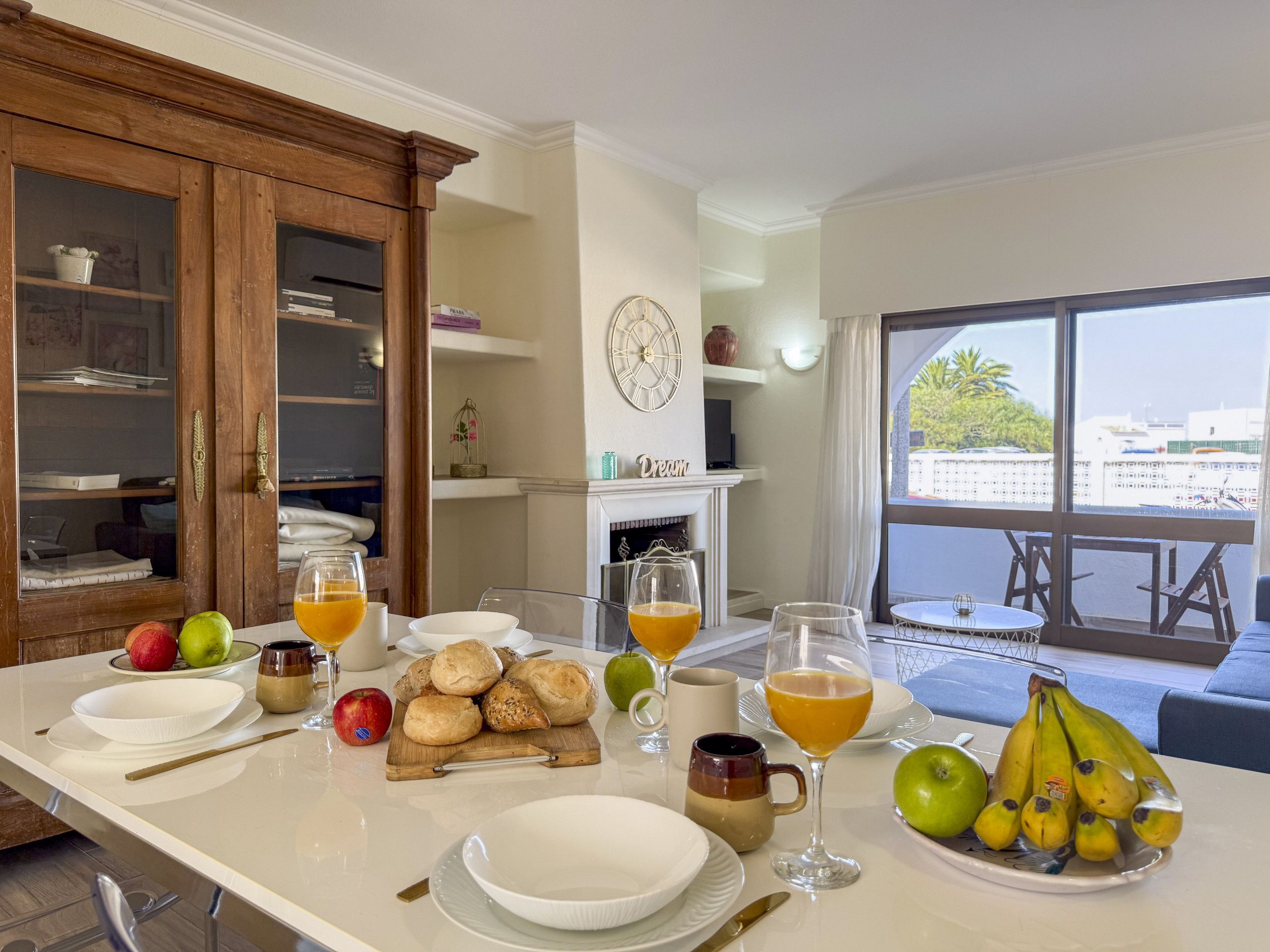 A breakfast setup with a variety of fruits, pastries, and beverages on a table.