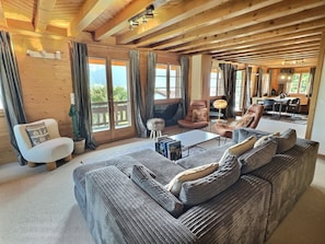 Ein gemütliches Wohnzimmer mit einer großen Couch, einem Couchtisch und einem Essbereich mit Tisch und Stühlen.