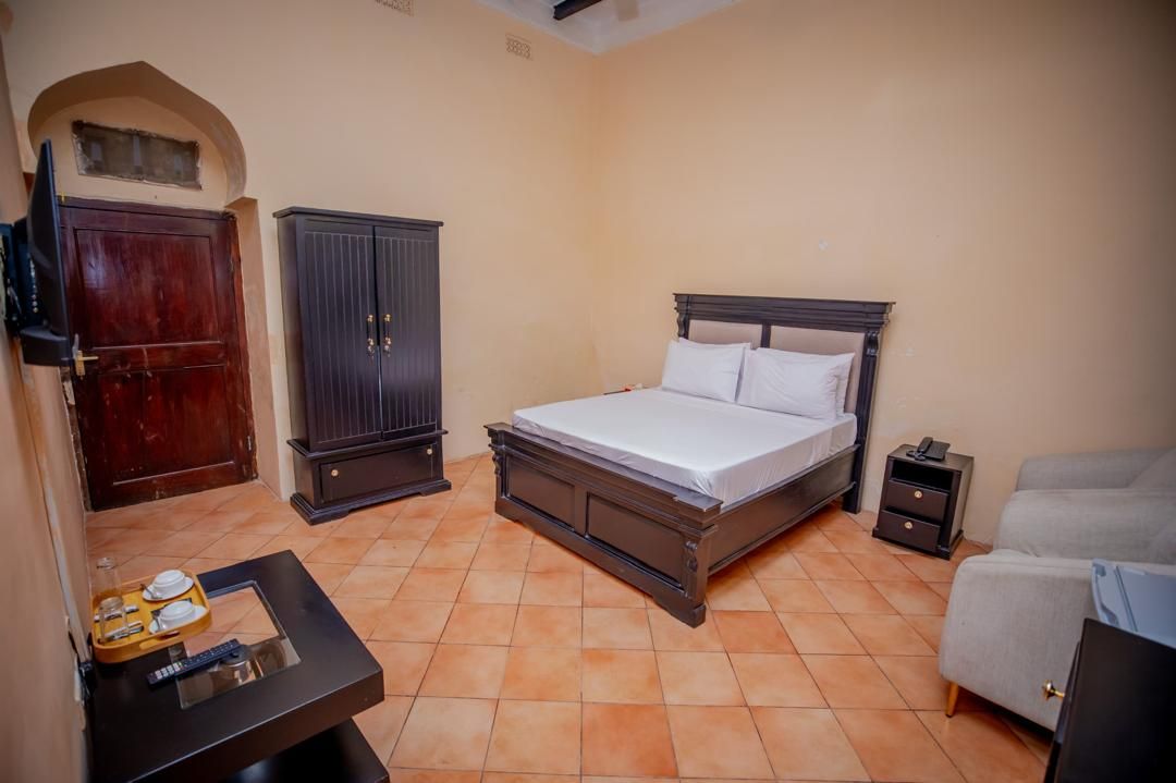 Une chambre à coucher comprenant un lit, une armoire, une table de chevet et une petite table avec un plateau.