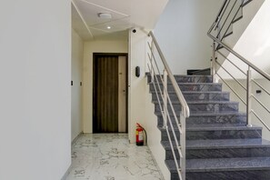 Una escala moderna amb graons de marbre i baranes metàl·liques.