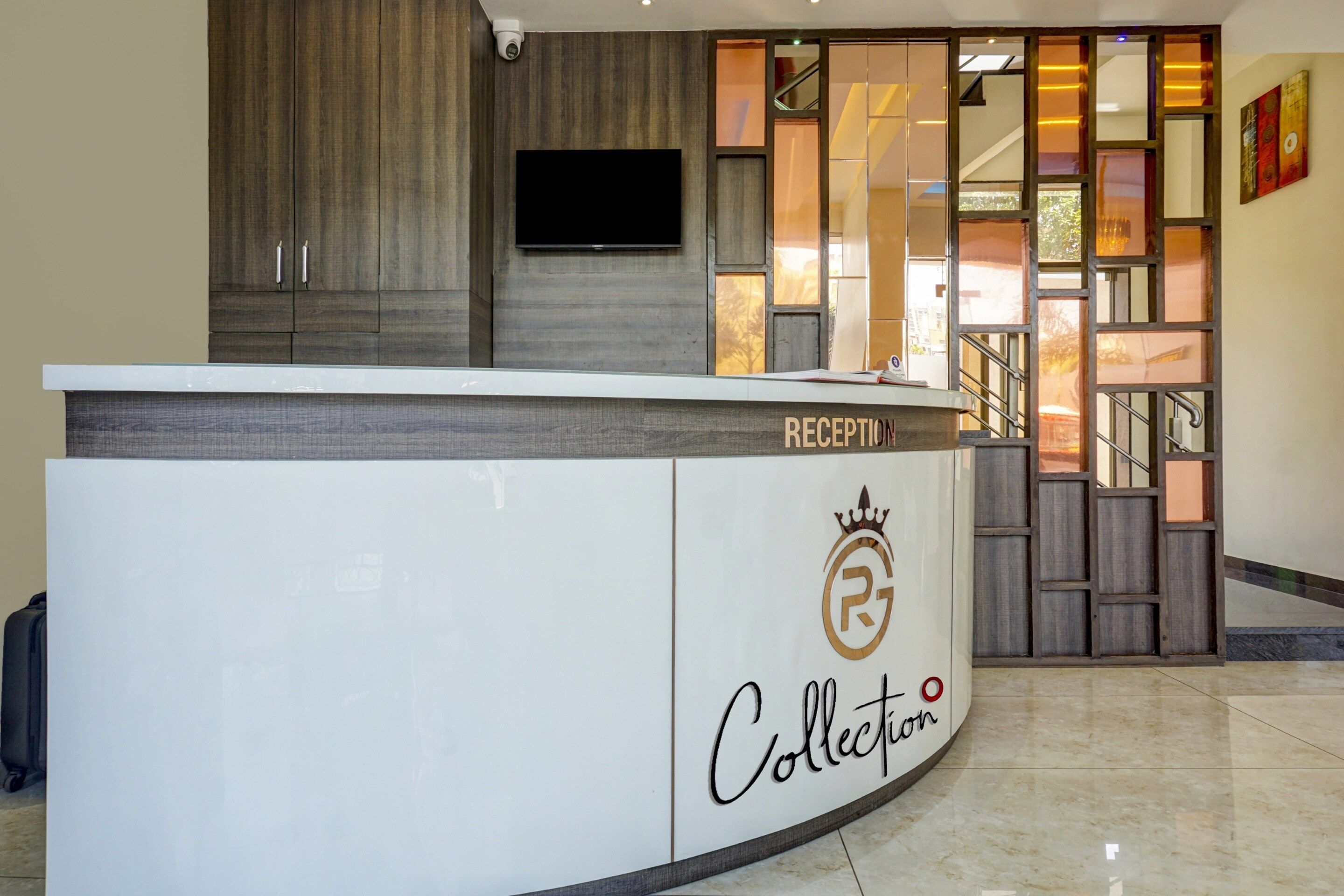 A reception desk with a 'RECEPTION' sign, a logo with a crown and 'R' inside a circle, and the word 'Collection' below.