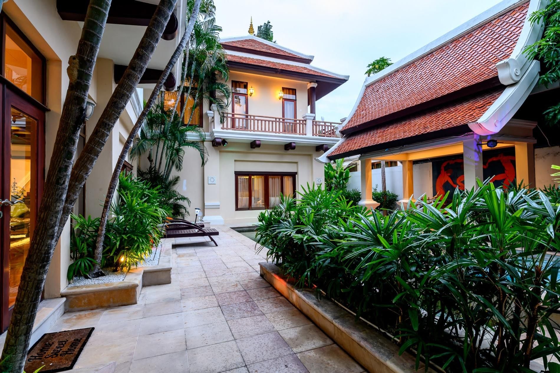 A courtyard with a pool, surrounded by lush greenery and traditional architecture.