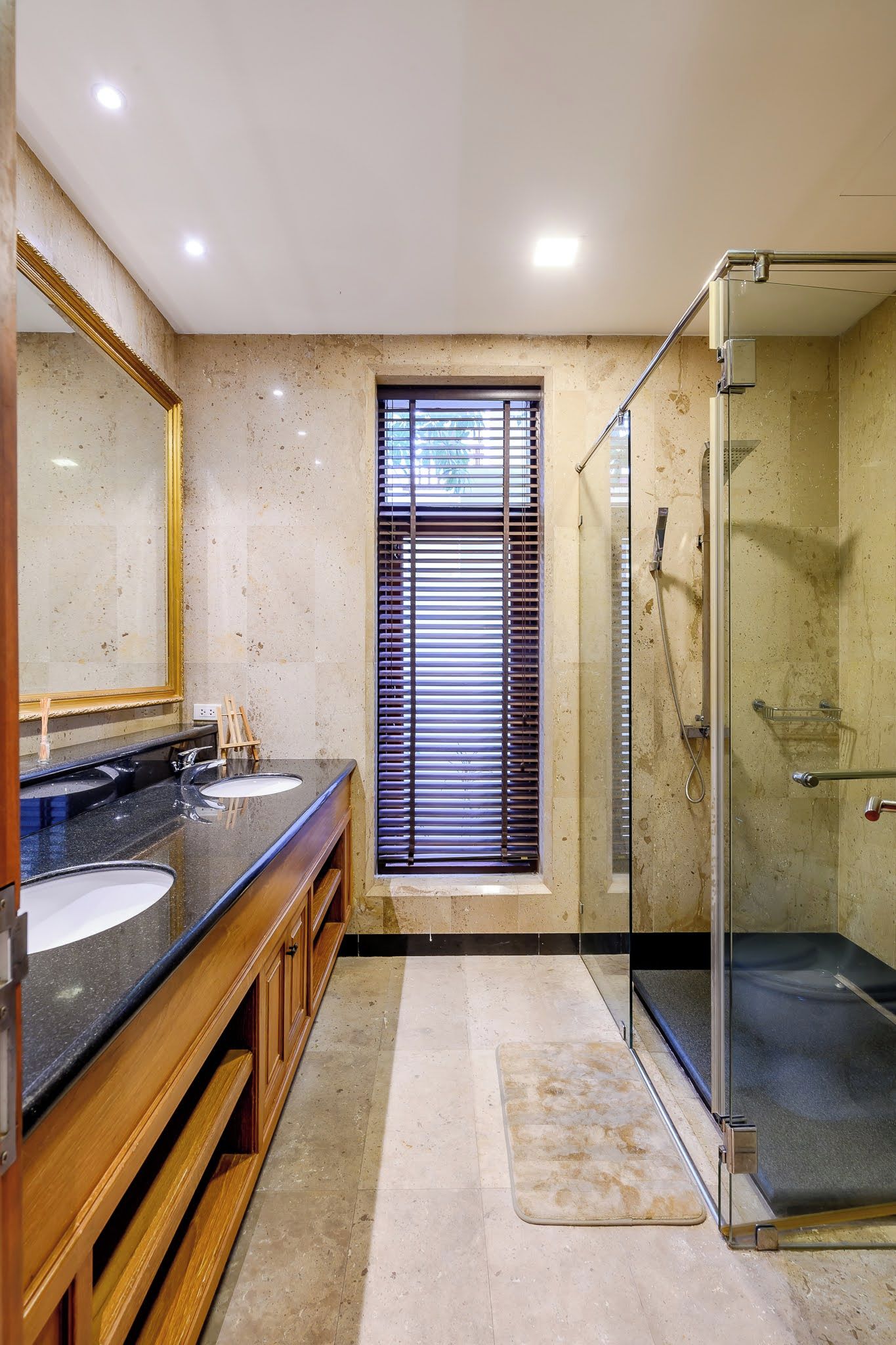 Un bagno con due lavandini, uno spazio doccia in vetro e un ampio specchio.