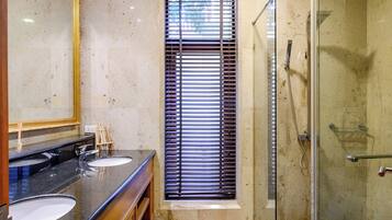 Un bagno con due lavandini, uno spazio doccia in vetro e un ampio specchio.
