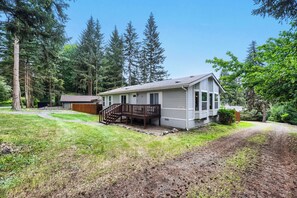 A single-story house with a front deck and a staircase leading to the entrance. - Modern Lakeside Escape w/ Sauna + Mountain Access (Snohomish)
