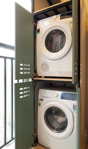 A stacked washer and dryer unit with visible control panels and a QR code. - Urban 2BR + 1BA | Central D1 | 500m Bui Vien (Thành phố Hồ Chí Minh)