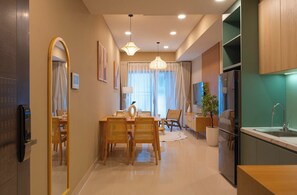 A modern kitchen with a built-in stove, a sink, and a dining area with a table and chairs. - Urban 2BR + 1BA | Central D1 | 500m Bui Vien (Thành phố Hồ Chí Minh)