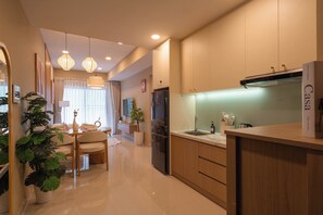 A modern kitchen with a built-in oven, a refrigerator, and a countertop with a sink. - High-Floor 2BR + 1BA | District 1 | Central City (Thành phố Hồ Chí Minh)