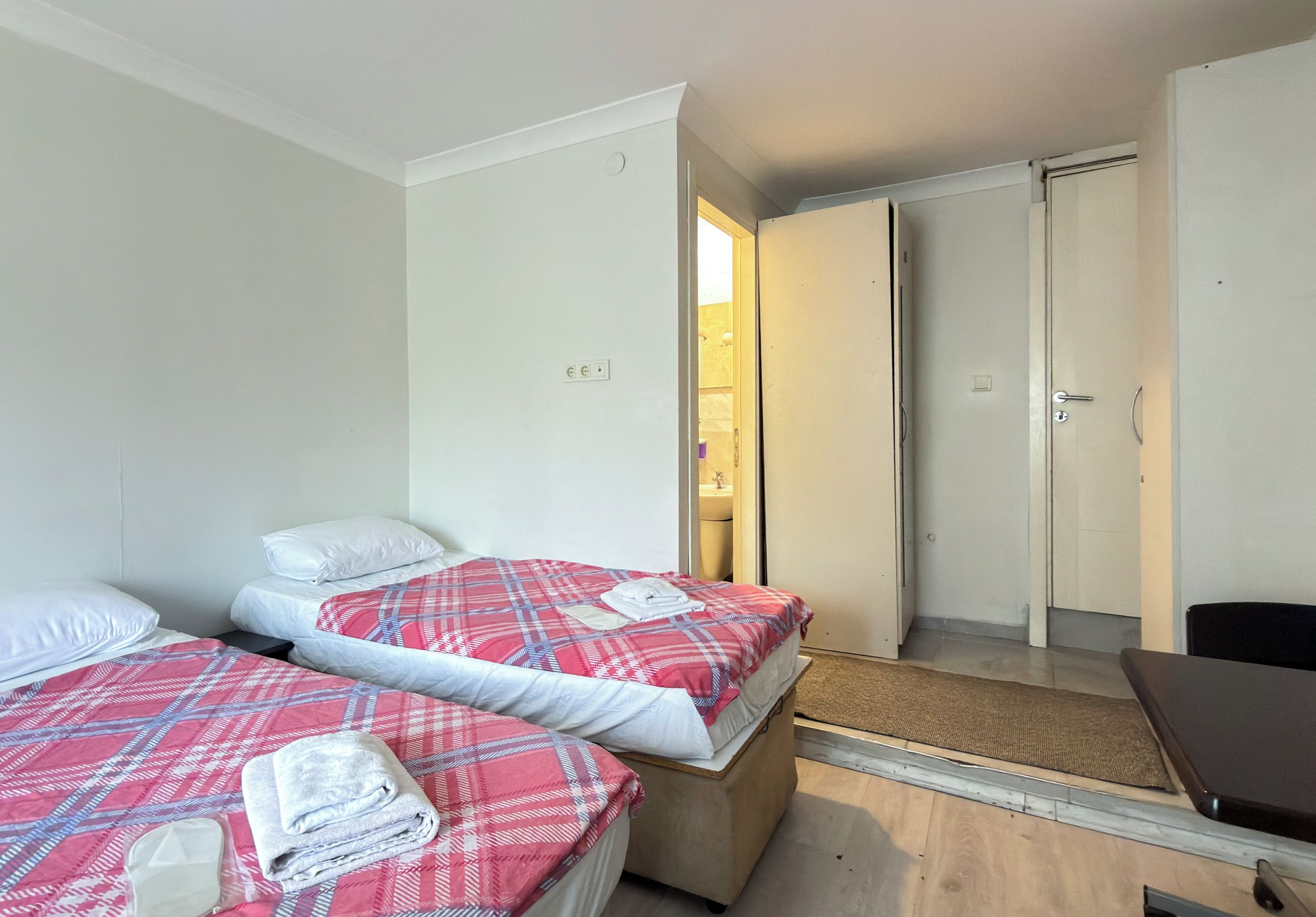 Une chambre d’hôtel avec deux lits, une salle de bain et une petite table.