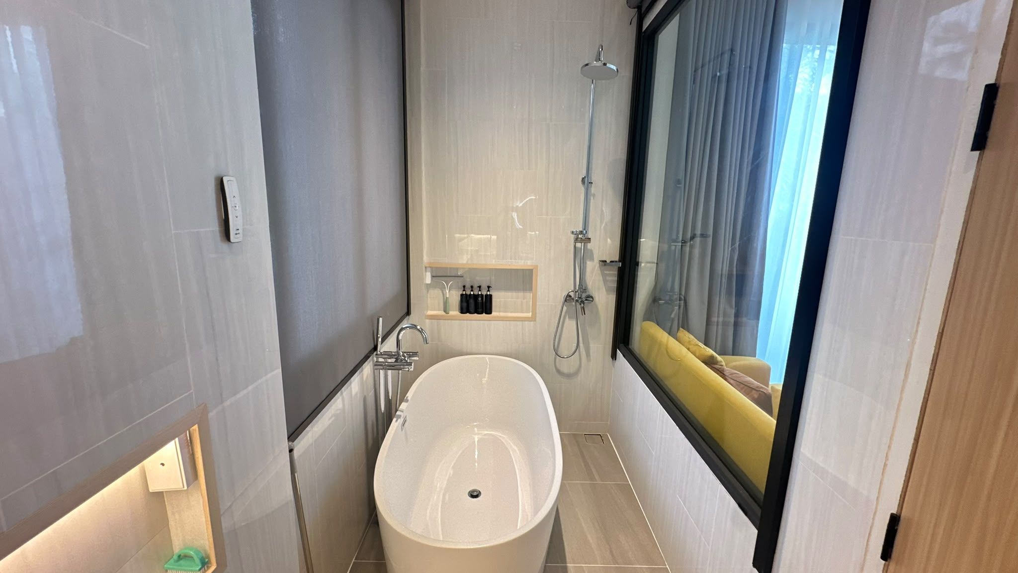 A modern bathroom with a freestanding bathtub, a shower, and a vanity with toiletries.