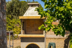 A brick oven structure with a chimney, surrounded by greenery and a clear sky. - Villa Kalimera - Three Bedroom Villa, Sleeps 6 (Gennadi)