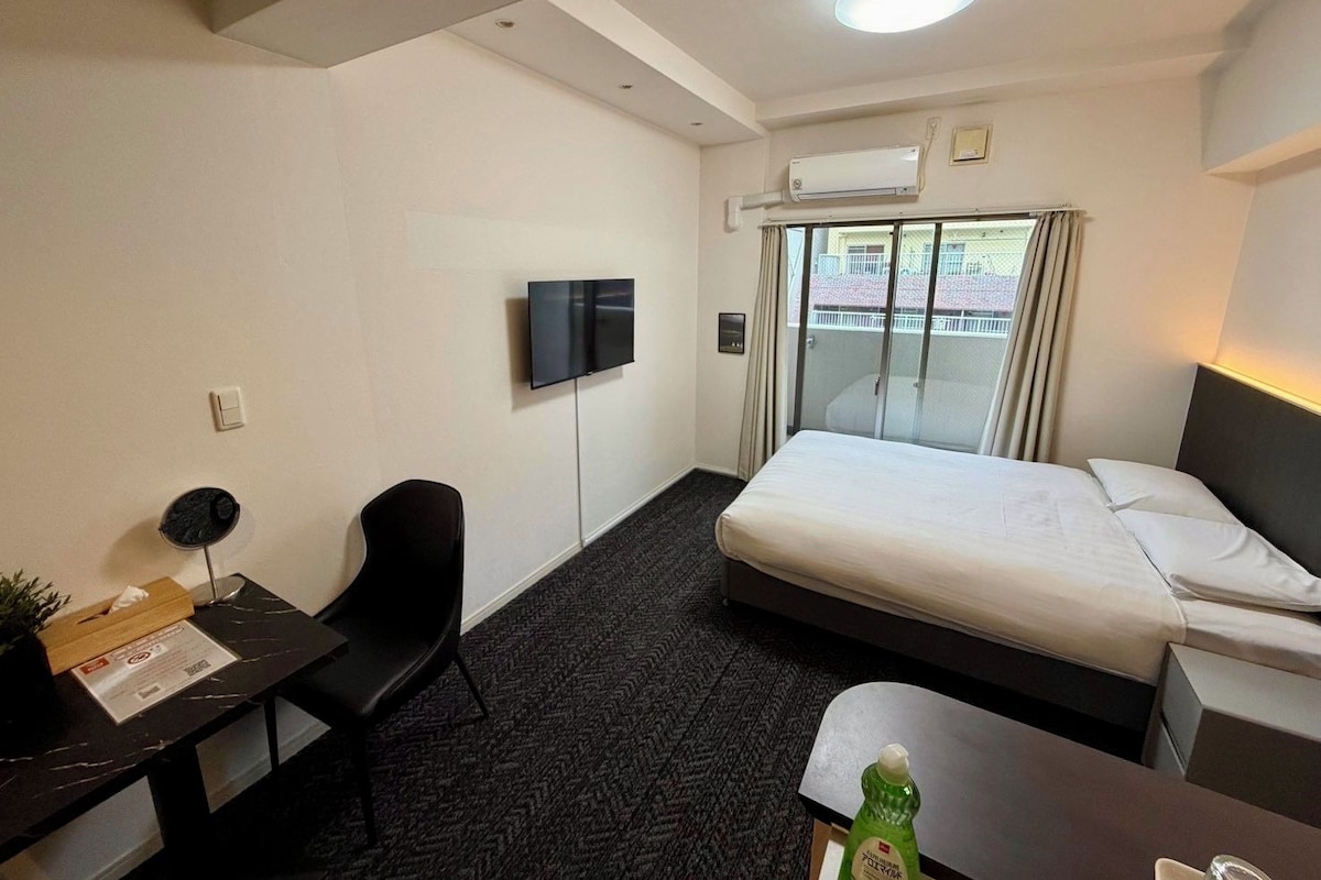 Une chambre d’hôtel équipée d’un lit, d’un bureau, d’une chaise, d’une télévision et d’un appareil de climatisation.
