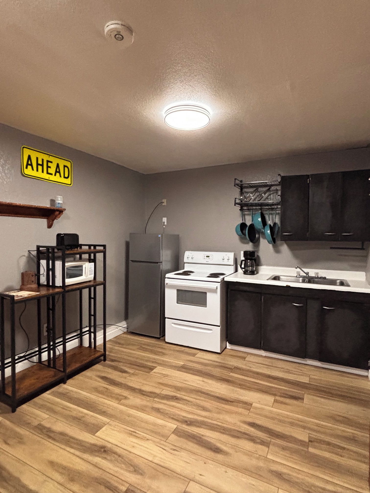 A kitchen with a microwave, refrigerator, stove, and cabinets.