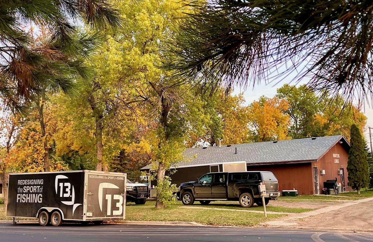 A trailer with 'REDESIGNING the SPORT of FISHING' text, a truck, and a building labeled 'HUNTERS LOBOCK'.