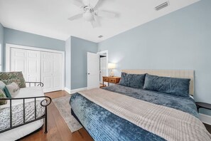 A bedroom with a bed, a nightstand, a ceiling fan, and a door. - 🚲Sugar Sand Bungalow | Pet Friendly | Bikes | Spacious Balcony | Walk to Beach🐾 (Santa Rosa Beach)