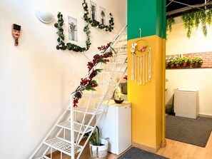 Una escalera con barandilla de metal blanco, decorada con follaje y bayas rojas.