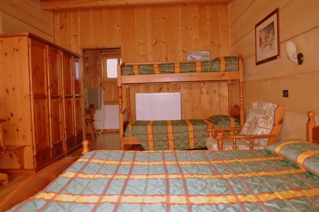 Ett rum inrett som en stuga, med våningssängar, en stol, ett skrivbord och en garderob.