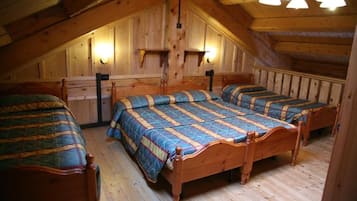 Une pièce avec trois lits en bois, des murs en bois et un plafond en pente.