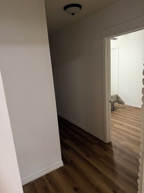 A hallway with wooden flooring and white walls. - Beautiful 4-bedroom house in enchanting West Orange with AC (West Orange)
