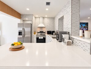 A modern kitchen with a stainless steel refrigerator, a microwave, an oven, and a coffee maker on the counter. - Private Pool | BBQ | Outdoor Dining (Hollywood)