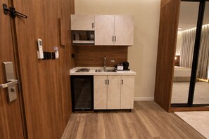 A compact kitchen with a microwave, sink, and dishwasher. - Abyat Alsharq Hotel (Madinah)