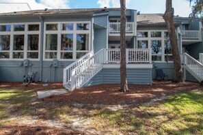 A two-story house with a front porch, a staircase, and a tree in the yard. - 3 Bedroom Townhome- With Resort Access (Edisto Island)