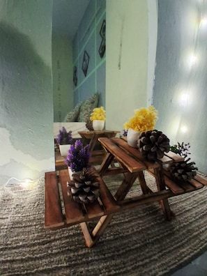 Una stanza accogliente con un tavolo di legno, pigne e piccole piante in vaso.