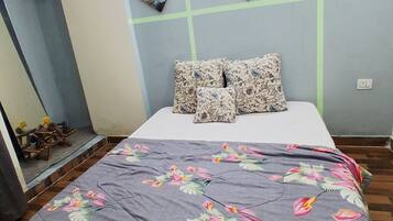 Een slaapkamer met een bed, een bloemenbedekking en wanddecoratie.