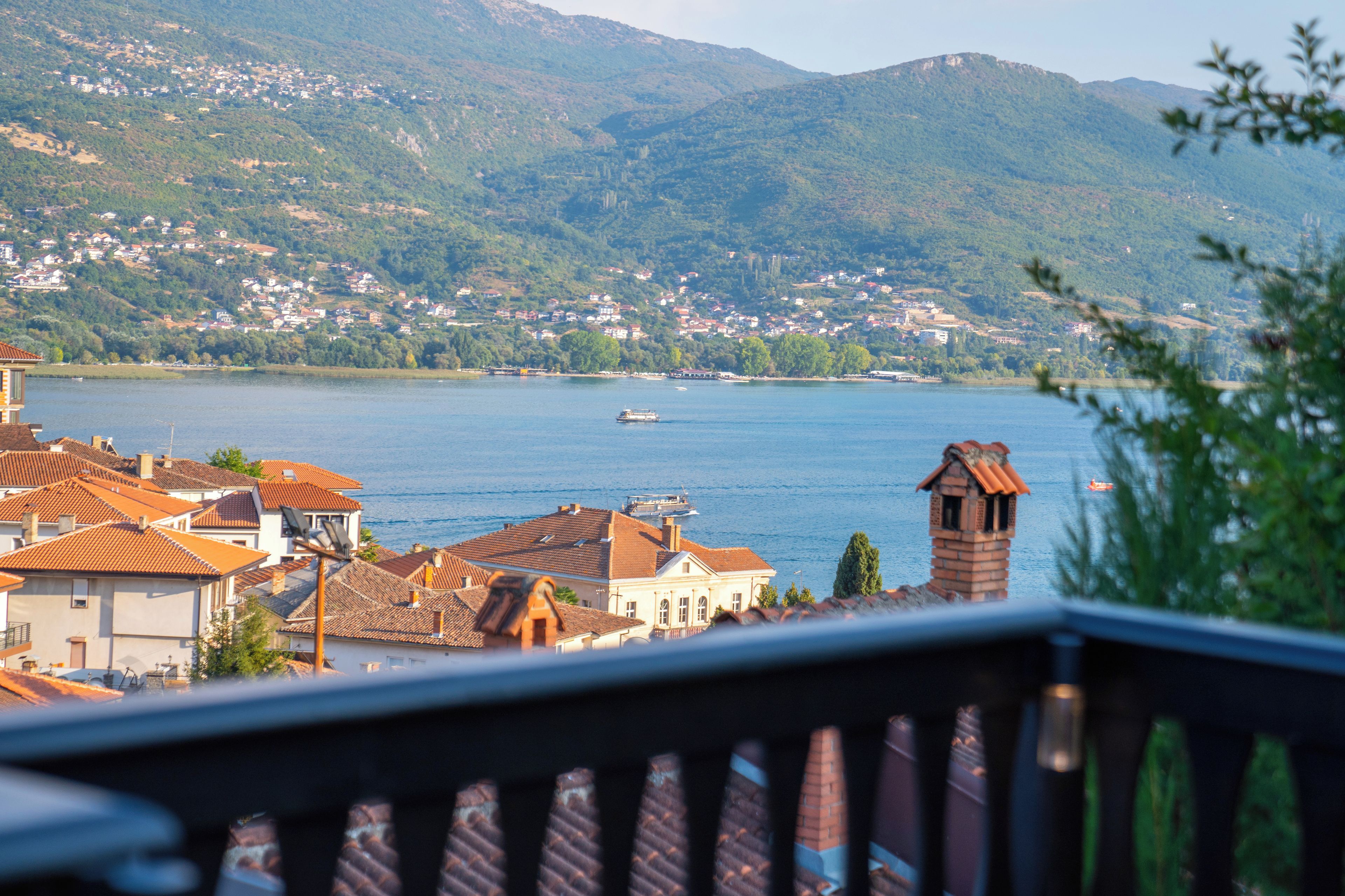 A lakeside town with buildings and a boat on the water.